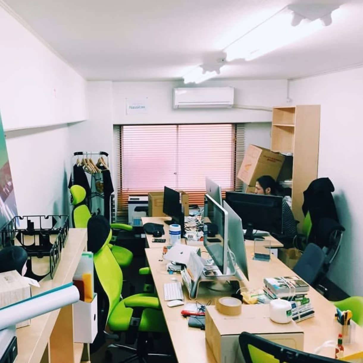 マンションの一室のようなところに、パソコンや本の乗ったデスクや椅子などの仕事の道具がぎっしり詰まっている写真